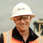 Smiling Decmil worker in orange high-vis vest on site