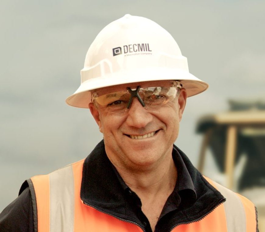 Smiling Decmil worker in orange high-vis vest on site